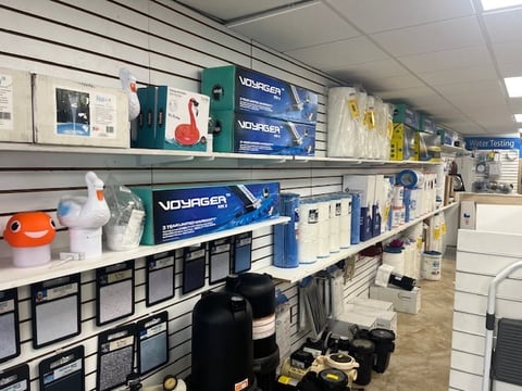 Retail shelving displaying Voyager water products, coolers, and home goods in a store aisle