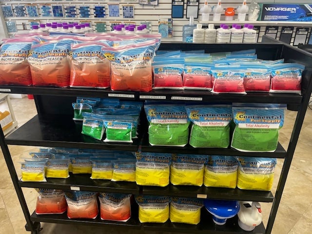 Black retail shelf displaying various colorful cleaning supplies and powders in red, blue, yellow, and green containers